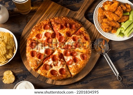 Homemade Pepperoni Pizza Chicken Wings and Beer for a Football Party Royalty-Free Stock Photo #2201834595