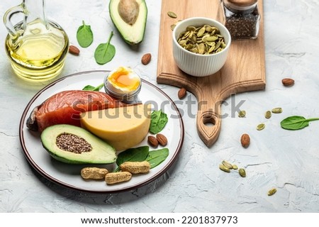 Keto diet food, salmon, avocado, cheese, egg, spinach and nuts. Ketogenic low carbs diet concept. Ingredients for healthy foods. Long banner format. top view. Royalty-Free Stock Photo #2201837973