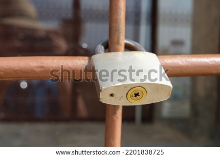 Old Locked Padlock Hanging On Metal railing.
