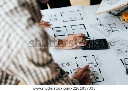 Close up of hands working brainstorming and measuring for cost estimating on paperworks and floor plan drawings about design architectural and engineering for houses and buildings. Royalty-Free Stock Photo #2201839335
