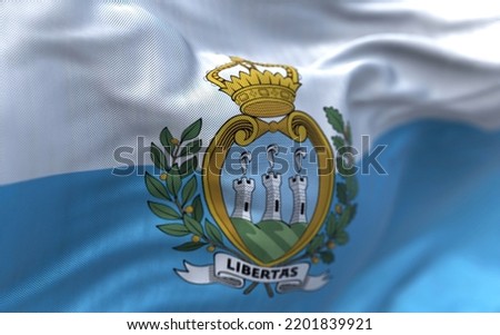Close-up view of the San Marino national flag waving in the wind. San Marino is a small country in Southern Europe enclaved by Italy. Fabric textured background. Selective focus