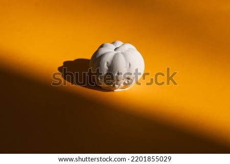 plaster figure of a pumpkin on a yellow background. Halloween concept