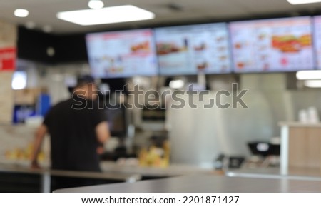 Customer placing an order at a fast food restaurant. Out of focus concept.