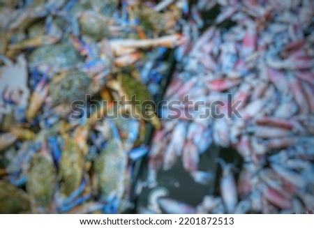 Blurry picture of lots of crabs and cuttlefish in the market.