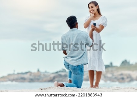 Beach proposal, engagement and surprise woman for love, care and relationship commitment together. Young, engaged and happy marry me couple, summer seaside date and special romance marriage outdoors Royalty-Free Stock Photo #2201883943