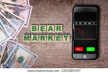 The inscription bear market next to the phone with a chart of stock prices. Fall in stock prices