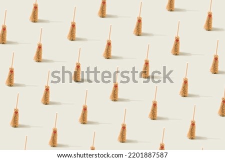 Halloween witch brooms pattern on a light green background. Witchcraft conceptual backdrop