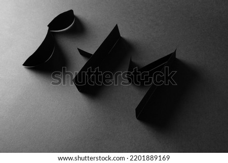 Paper alphabet letters BHM with shadow on black background. Black History Month concept. Flat lay. Copy space.