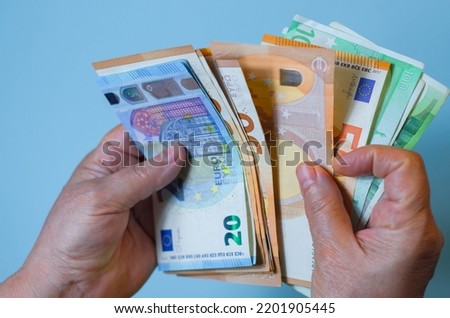 Female hands holding euro banknotes on a blue background. Euro Money. euro cash background
