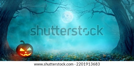 Happy Halloween holiday background with copy space.
Dark  landscape with creepy trees and moon. Fairytalle  forest with pumpkin Jack-o'-lantern.
Ominous sky on Halloween night.