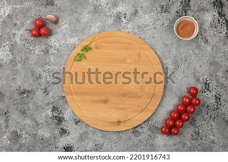 Kitchen background with ingredients, minimal cooking concept, business card for restaurant, cafe, shop, menu, tomatoes, garlic, herbs and wooden board on concrete table, selective focus, top view