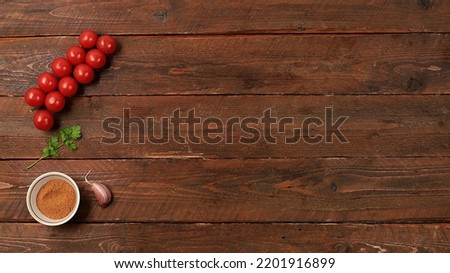 Kitchen background with ingredients,minimal cooking concept,business card for restaurant,cafe,shop,menu,tomatoes,garlic,greens on wooden table,selective focus,top view,space for text,