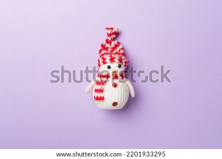 Small Christmas snowman on color background, top view.