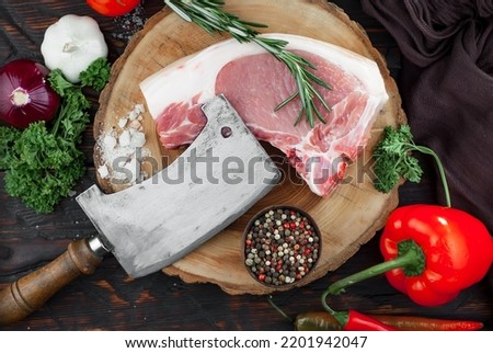 Raw meat with spices in a composition with kitchen accessories.