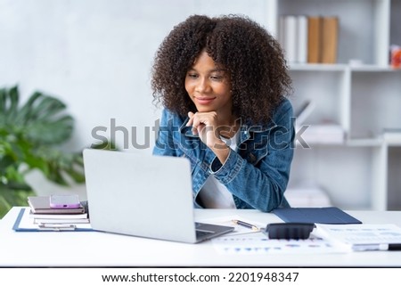 Smiling African American businesswoman with great joy Checking email after receiving good news on laptop at office Royalty-Free Stock Photo #2201948347