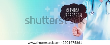 Clinical research. Doctor holding sign. Text is in speech bubble. Blue background with icons