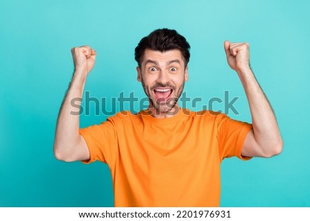 Closeup photo of young attractive handsome funny man excited fists up celebrate hooray winner tournament positive nice isolated on aquamarine color background