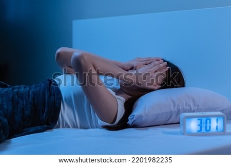 Annoyed, Stressed, asian young beautiful, pretty woman, girl suffering from insomnia, awake in bed at night, covering face with hand because of disturbed loud noise, unable sleep. Restless people. Royalty-Free Stock Photo #2201982235