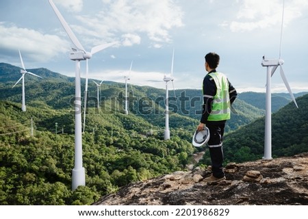 Young maintenance engineer man working in wind turbine on the mountain,Power generation Saving and using renewable energy concept. Royalty-Free Stock Photo #2201986829