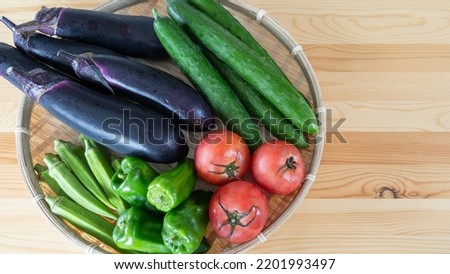 Summer vegetables on the table. Eggplants, Japanese cucumbers, tomatoes, okra and green peppers.