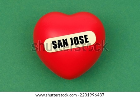 Love for the city, homeland. On a green surface lies a red heart with the inscription - San Jose