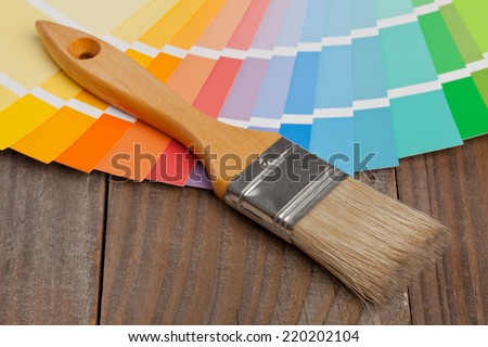 Color chart guide for renovation with brush on wooden surface