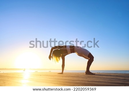 Young sporty woman training in outdoor, working out at animal flow style, making crab position.  Royalty-Free Stock Photo #2202059369
