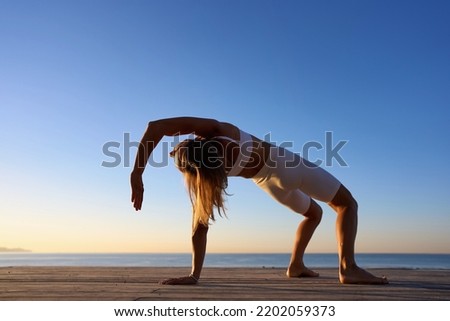 Young sporty woman training in outdoor, working out at animal flow style, making crab position.  Royalty-Free Stock Photo #2202059373