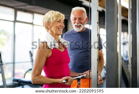 Senior fit man and woman doing exercises in gym to stay healthy Royalty-Free Stock Photo #2202091595