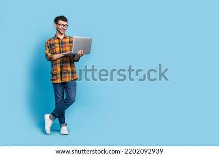 Full size portrait of positive nice person hold use wireless netbook empty space isolated on blue color background