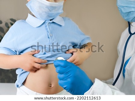 Medical examining boy in clinic. Little child checked by doctor. Pediatrician with stethoscope with face mask and toddler in a hospital. Check heart lungs of kid. Pediatric checkup in hospital. mpox