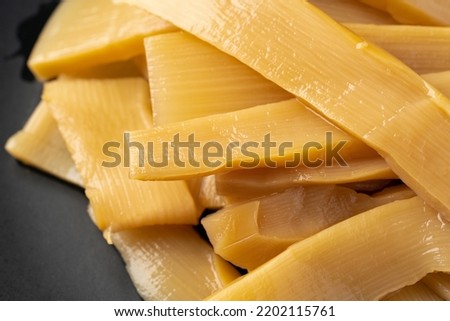 Menma.
bamboo shoots boiled, sliced, fermented, dried or preserved in salt, then soaked in hot water and sea salt.