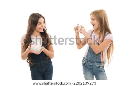 Cheese. Cute children making photo with smartphone camera. Little photographer having a photo shoot with friend holding gift box. Small child taking photo session of birthday girl