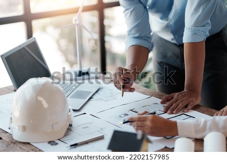 Architect or engineer are designing house, modifying plan, creating construction project and addition according to customer requirement. Royalty-Free Stock Photo #2202157985