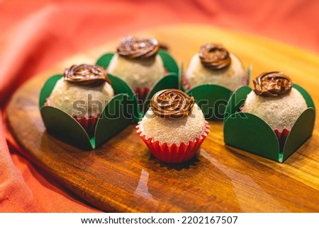 Brazilian gourmet Brigadeiro with powdered milk and hazelnut cream on a wooden board. Close-up photo. Brazilian food, dessert. Traditional sweet in Brazil at parties and events.