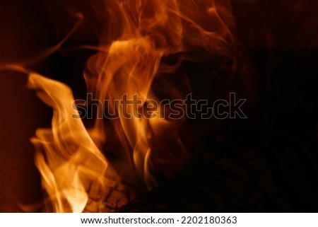 Bonfire burning and bringing in some heat, light and lovely atmosphere. Enjoy the fire in fireplace, as a campfire or simply as a background image. Closeup of abstract red, orange and yellow flames.