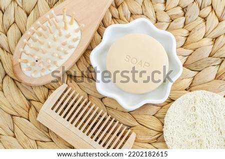 Bar of soap (solid shampoo), loofah bath sponge, wooden hair brush and hair (beard) comb. Eco friendly toiletries set. Natural beauty treatment, skin care, zero waste concept. Top view. 