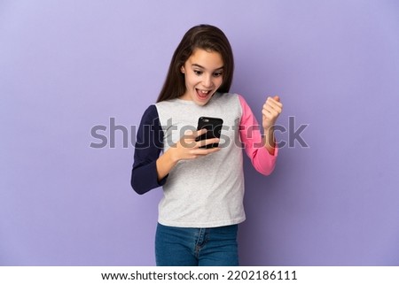 Little girl isolated on purple background surprised and sending a message