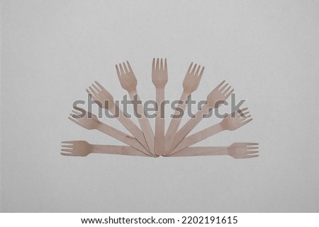 Wooden, disposable tableware on a gray background. Eco-friendly materials.