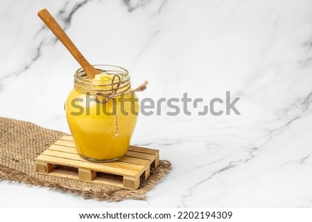 Homemade Melted ghee clarified butter. Bio Ayurveda Lactose free high quality butter on a light background. place for text, top view. Royalty-Free Stock Photo #2202194309