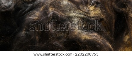 Golden sparkling abstract background, luxury black smoke, acrylic paint underwater explosion, cosmic swirling ink Royalty-Free Stock Photo #2202208953