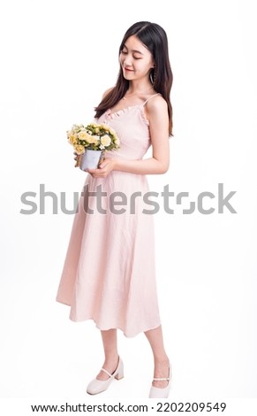 A woman in a pink dress with a pot of flowers