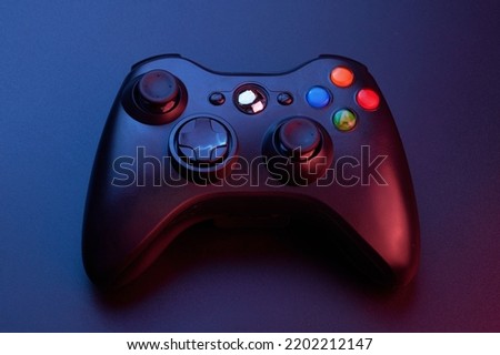 Black video game controller, joystick for game console isolated on black background. Gamer control device close-up
