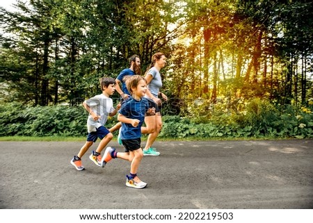 A Family exercising and jogging together at an outdoor park Royalty-Free Stock Photo #2202219503