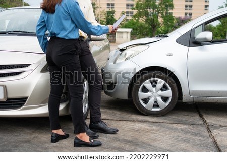 Two Drivers using a smartphone to exchange phone numbers and social media after a car accident. Concept of claim insurance for a car accident online after send photo and evidence to insurance company Royalty-Free Stock Photo #2202229971