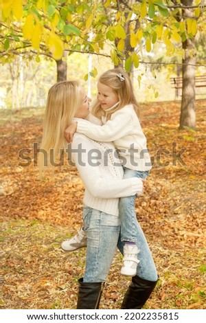 Happy joyful family, mother and daughter have a rest in autumn forest