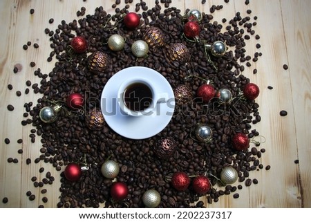 Cup of coffee on coffee beans with spices and Christmas holiday decoration on wooden background
