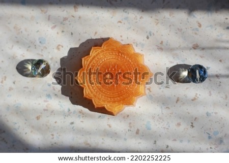 Delicate orange yoga handmade  carved soap. Soap in form of mandala flower  sign. Delicate spiritual skin care. Royalty-Free Stock Photo #2202252225