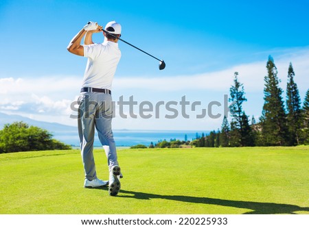 Golfer Hitting Ball with Club on Beatuiful Golf Course Royalty-Free Stock Photo #220225933
