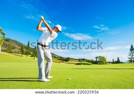 Golfer Hitting Golf Shot with Club on the Course  Royalty-Free Stock Photo #220225936